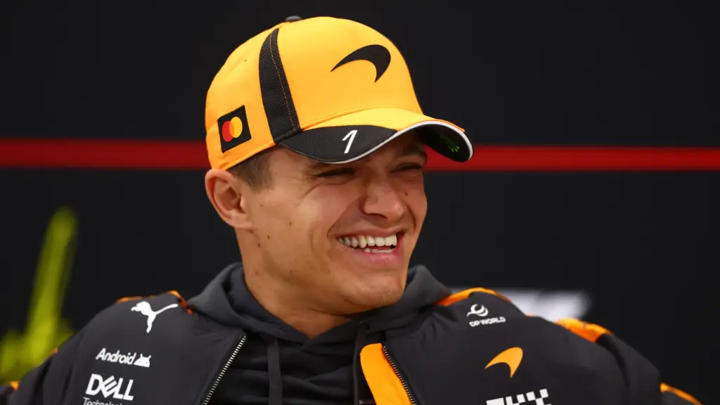 Lando Norris smiling in McLaren team kit