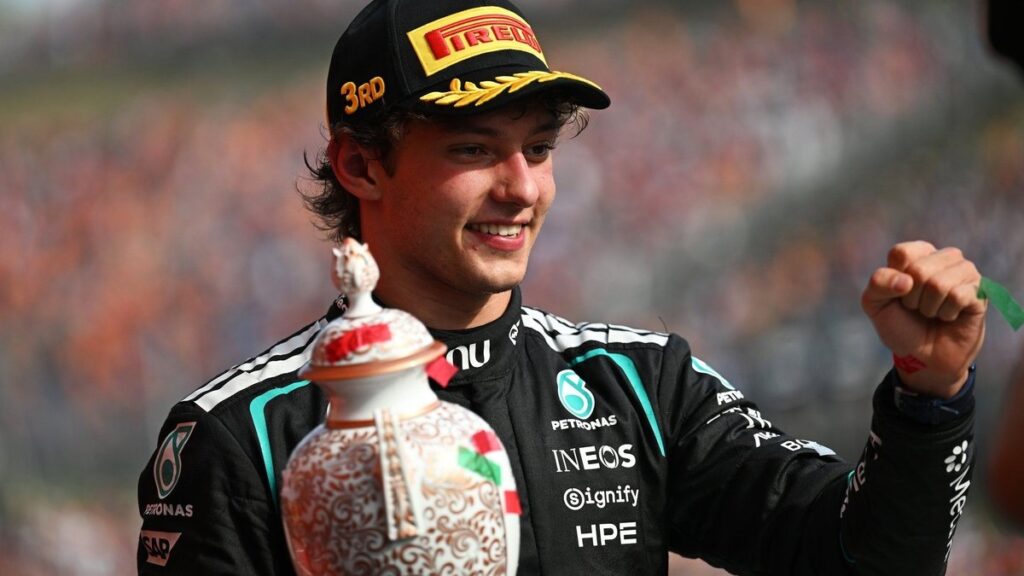 Kimi Antonelli Baku: Kimi Antonelli celebrating on the podium in Mercedes team kit, holding a trophy.
